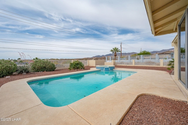 view of swimming pool featuring a fenced backyard, a pool with connected hot tub, and a patio area