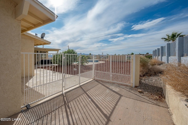 view of gate featuring a patio area and fence
