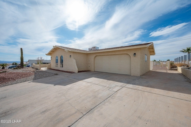 view of front of home with a garage, stucco siding, and driveway