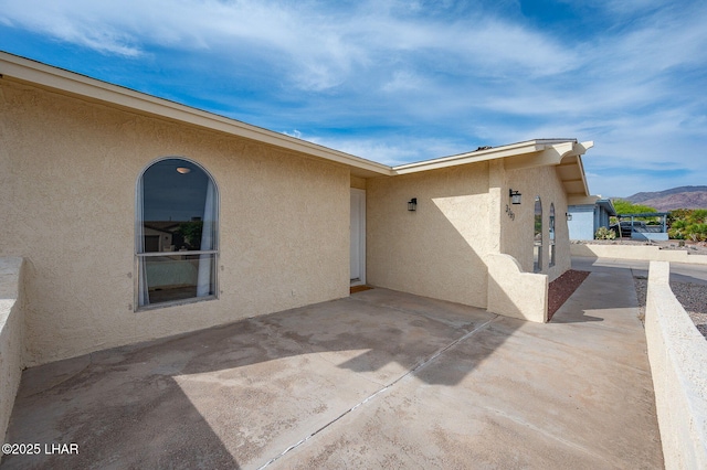 exterior space featuring a patio, stucco siding, and a mountain view