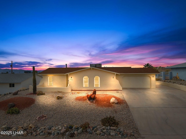 single story home with concrete driveway, stucco siding, and a garage