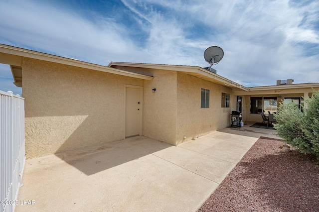 rear view of house featuring a patio and stucco siding