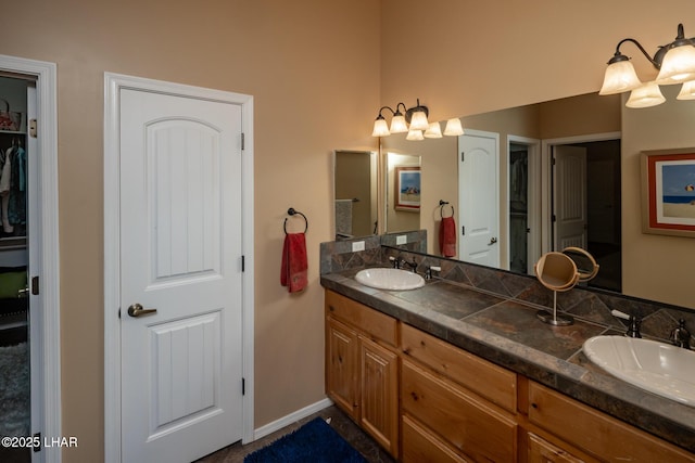bathroom featuring a chandelier, a sink, and double vanity