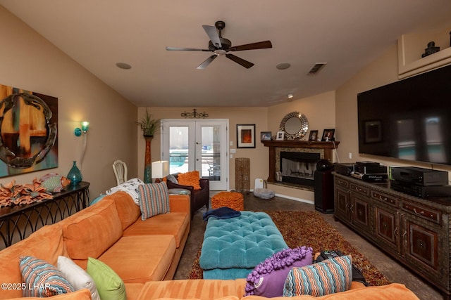 living room with vaulted ceiling, a ceiling fan, french doors, a fireplace, and visible vents