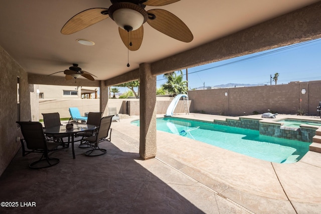 view of pool with a ceiling fan, a water slide, a patio, and a fenced backyard