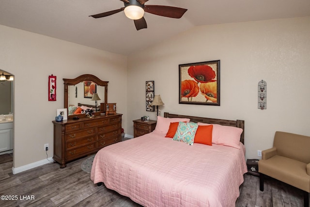 bedroom with ensuite bathroom, baseboards, lofted ceiling, wood finished floors, and ceiling fan
