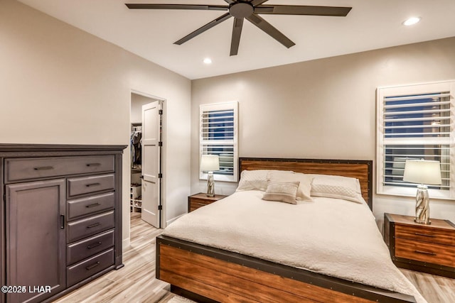 bedroom with ceiling fan, a spacious closet, recessed lighting, and light wood-style floors