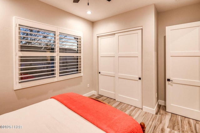 unfurnished bedroom featuring recessed lighting, a ceiling fan, baseboards, a closet, and light wood-type flooring