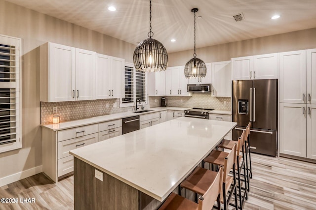 kitchen with a kitchen island, white cabinetry, and stainless steel appliances