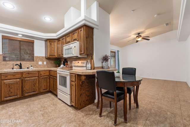 kitchen featuring sink, tasteful backsplash, ceiling fan, kitchen peninsula, and white appliances