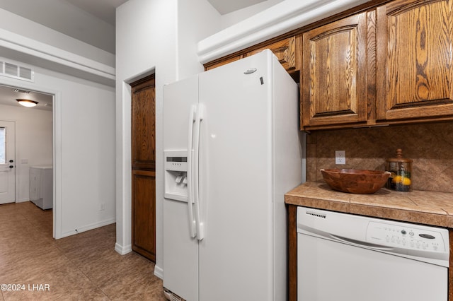 kitchen with tasteful backsplash, tile countertops, and white appliances