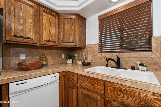 kitchen with sink, decorative backsplash, and dishwasher