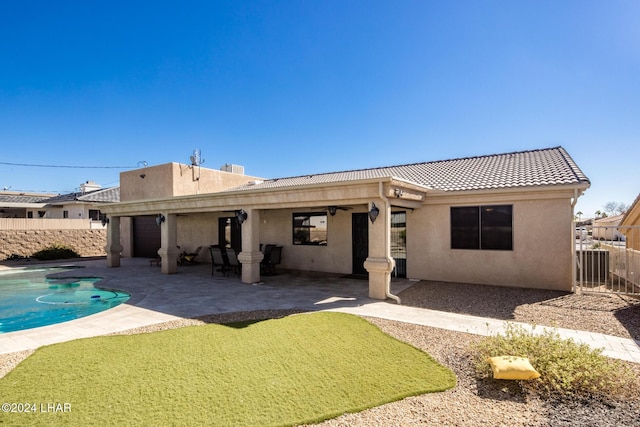 rear view of house featuring a fenced in pool, a patio, and ceiling fan