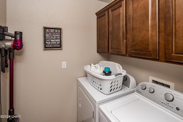 clothes washing area featuring independent washer and dryer and cabinets