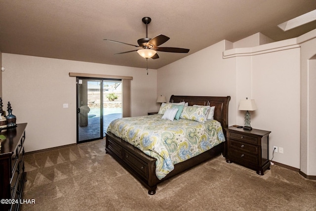 carpeted bedroom with vaulted ceiling with skylight, access to exterior, and ceiling fan