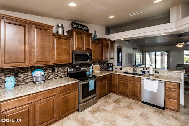 kitchen featuring appliances with stainless steel finishes, sink, kitchen peninsula, and decorative backsplash