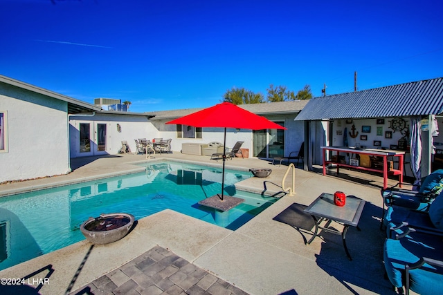 view of swimming pool featuring french doors and a patio area