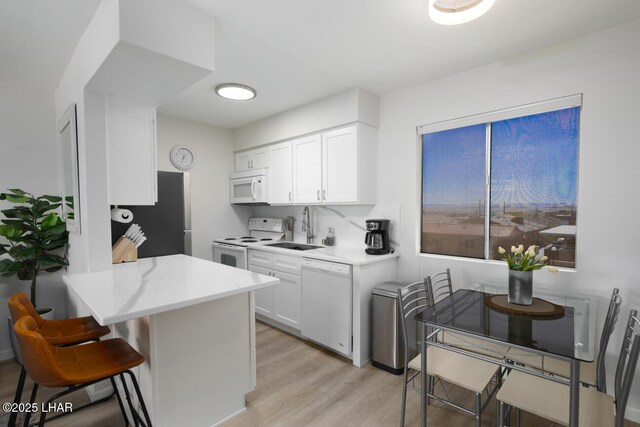 2100 Swanson Ave Unit 209, Lake Havasu City, AZ 86403 - kitchen featuring white appliances, a sink, light wood-type flooring, and white cabinets