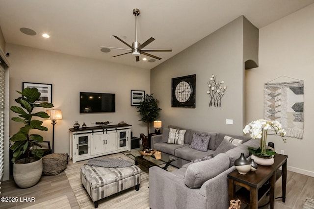 living area featuring a ceiling fan, recessed lighting, arched walkways, light wood finished floors, and lofted ceiling