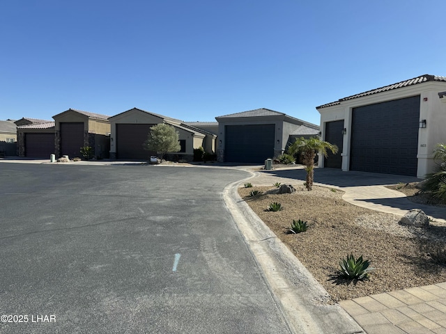 view of front of house featuring stucco siding, driveway, and a tile roof