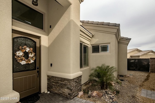 607 Veneto Loop, Lake Havasu City, AZ 86403 - property entrance with stucco siding, stone siding, and fence