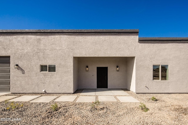 view of exterior entry with a patio