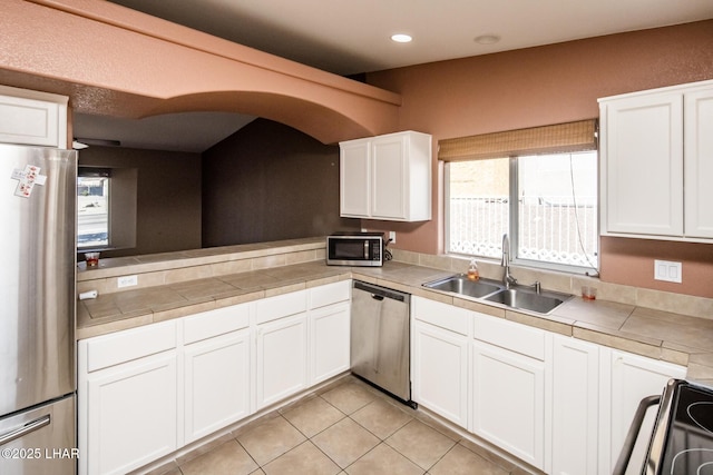 kitchen featuring a sink, white cabinetry, appliances with stainless steel finishes, and light tile patterned floors
