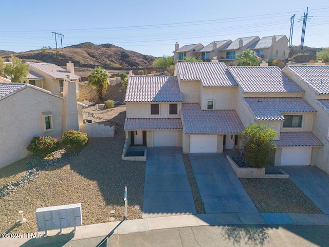 view of front of home with a tile roof, stucco siding, concrete driveway, an attached garage, and fence