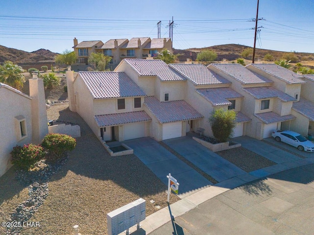 view of front of home featuring a residential view, driveway, a tiled roof, and stucco siding