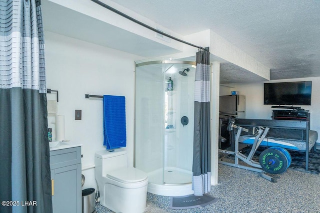 full bathroom featuring toilet, a shower stall, a textured ceiling, and vanity