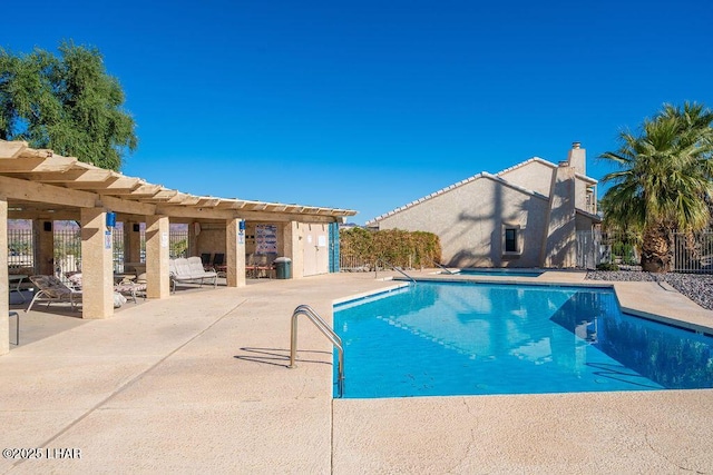 pool with a patio area and fence