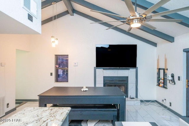 living room featuring baseboards, a ceiling fan, a tile fireplace, vaulted ceiling with beams, and marble finish floor