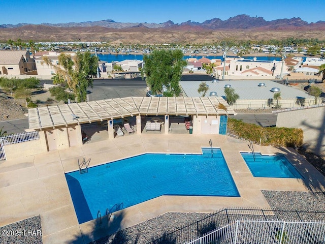 pool featuring a patio area, fence, and a mountain view