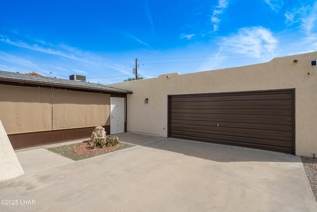 adobe home with a garage and stucco siding