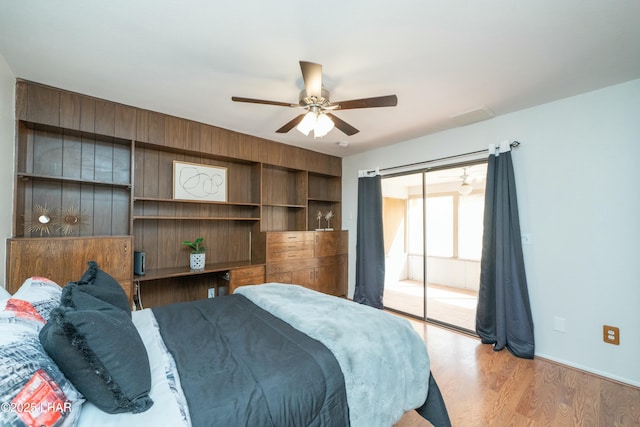 bedroom featuring a ceiling fan, access to outside, and wood finished floors