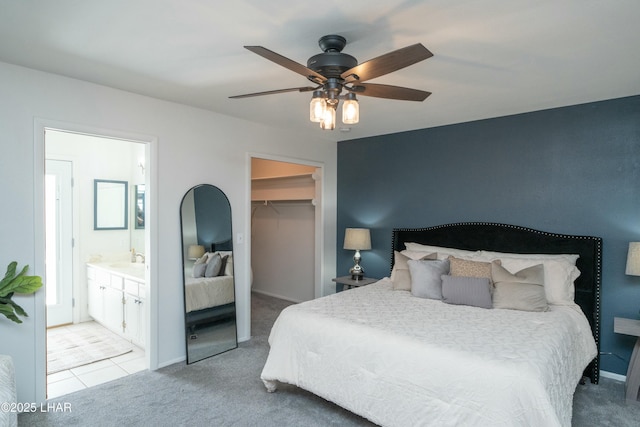 bedroom with a closet, light colored carpet, a sink, and a spacious closet