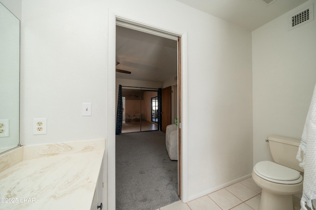 bathroom featuring visible vents, toilet, vanity, tile patterned flooring, and baseboards