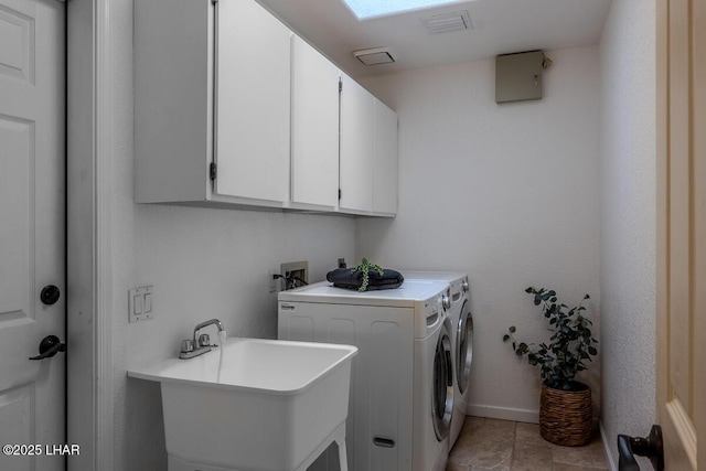 washroom featuring independent washer and dryer, a sink, cabinet space, and baseboards