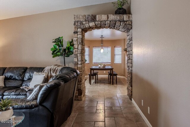 kitchen with a sink, stainless steel appliances, open shelves, and light stone countertops