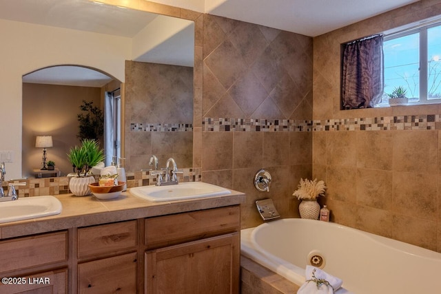 bathroom featuring a sink, a jetted tub, and double vanity