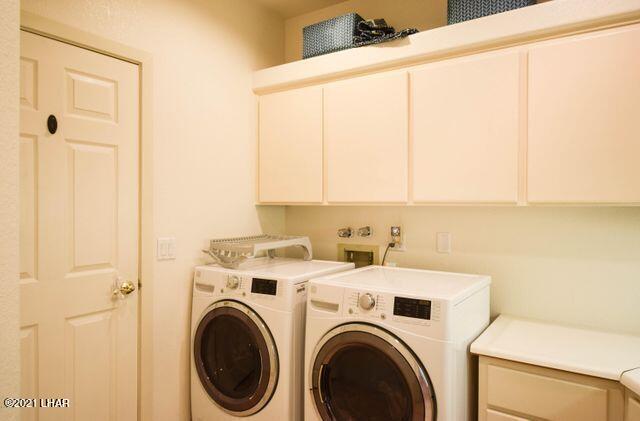 washroom featuring washing machine and dryer and cabinets