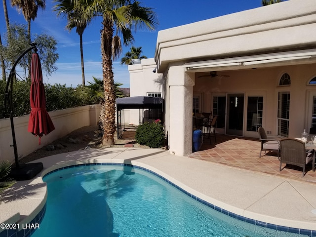 view of swimming pool featuring ceiling fan and a patio area