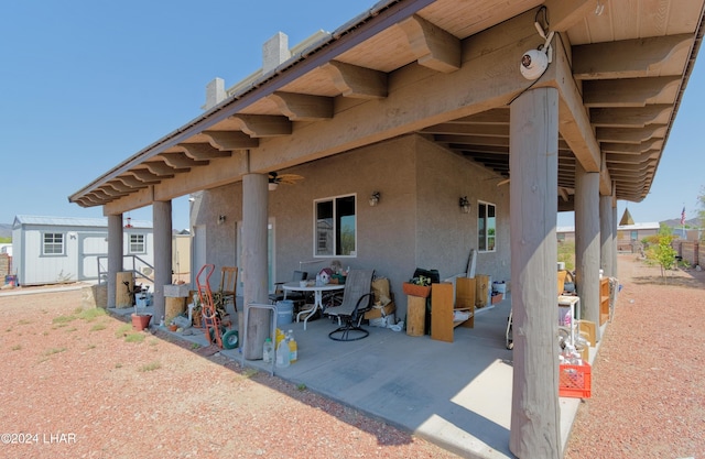 view of patio / terrace with a shed, a ceiling fan, and an outdoor structure