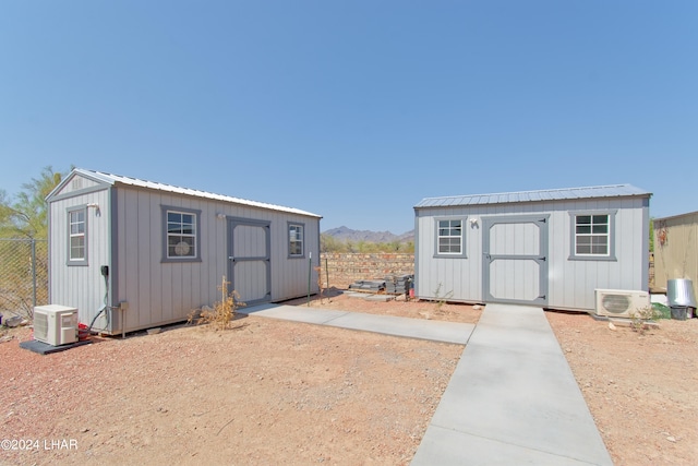 view of shed with ac unit and fence