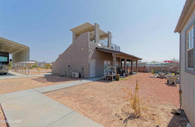 exterior space with a detached carport, stucco siding, and a balcony