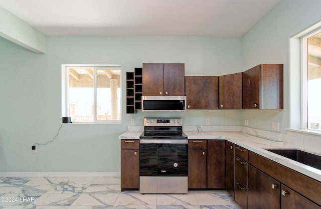 kitchen with stainless steel appliances, light stone countertops, dark brown cabinetry, and marble finish floor