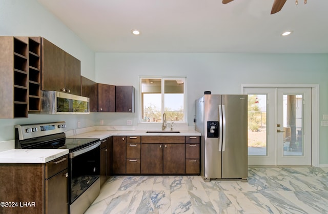 kitchen featuring dark brown cabinetry, appliances with stainless steel finishes, light countertops, and a sink