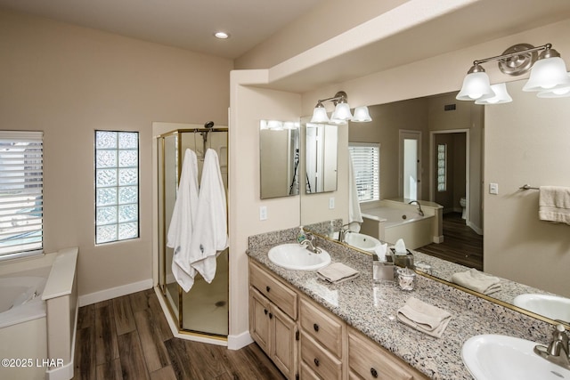 full bathroom featuring toilet, vanity, shower with separate bathtub, and wood-type flooring