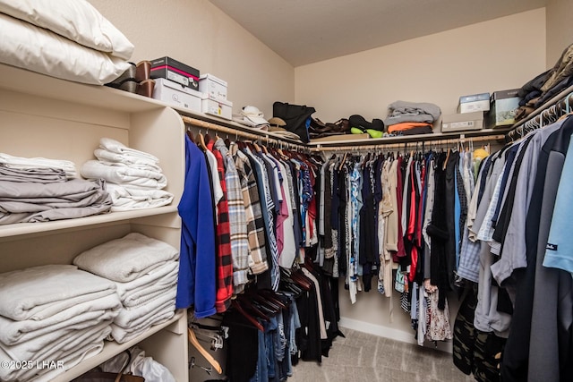 spacious closet featuring vaulted ceiling and carpet floors