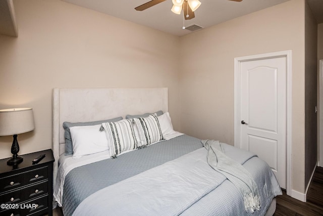 bedroom with dark hardwood / wood-style flooring and ceiling fan